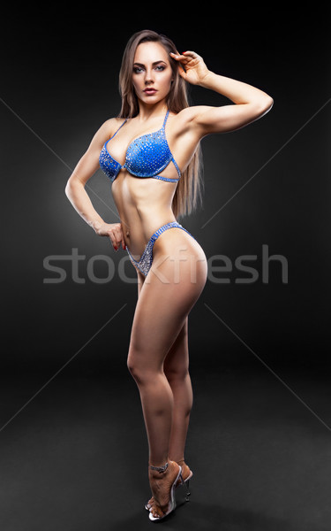 Frumos bruneta femeie prezinta albastru bikini Imagine de stoc © restyler
