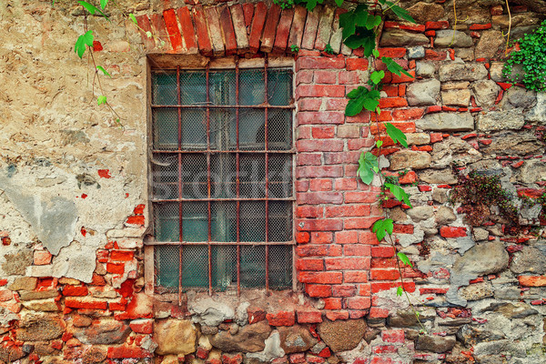 Fragment of old abandoned brick house with closed window behind iron bars in small italian town in P Stock photo © rglinsky77