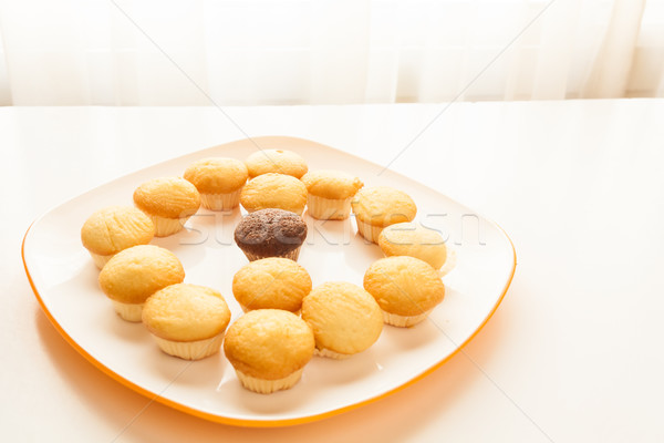 Tasty yellow muffins and chocolate muffin in center Stock photo © robinsonthomas