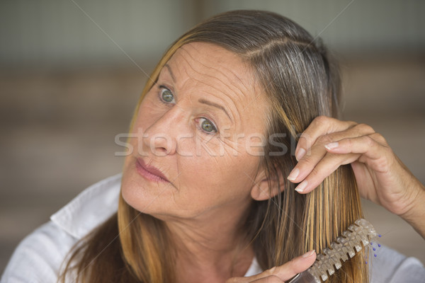 Attractive woman brushing long hair portrait Stock photo © roboriginal