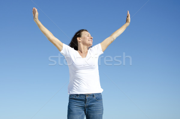Happy cheerful woman with arms up Stock photo © roboriginal