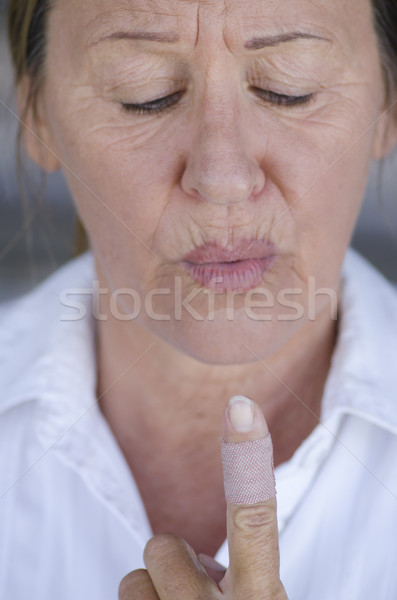 Stressed Woman blowing injured band aid finger  Stock photo © roboriginal