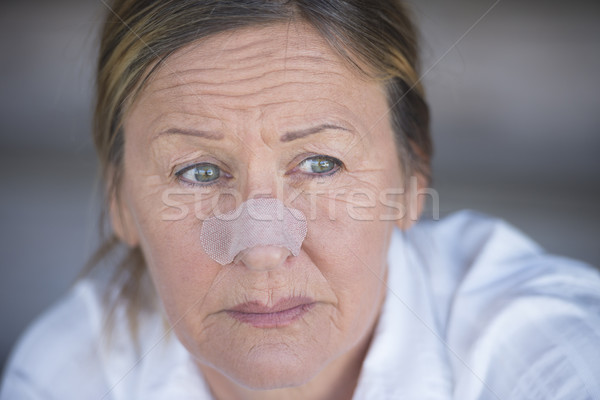 Sad woman with band aid on injured nose Stock photo © roboriginal