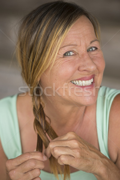 Joyful active mature woman  braiding hair Stock photo © roboriginal