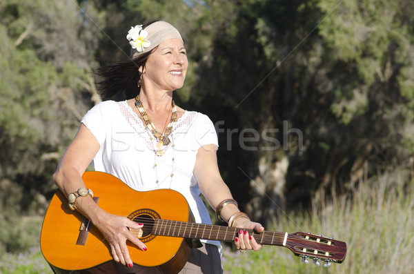 Happy mature hippie woman with guitar Stock photo © roboriginal