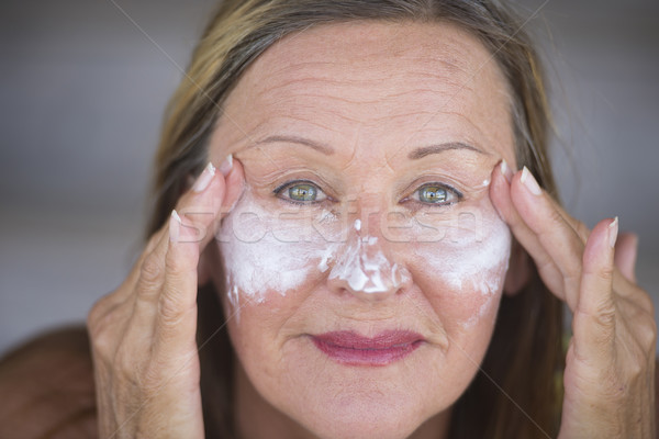 Confident mature woman face creme skin care Stock photo © roboriginal