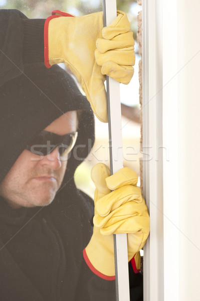 Thief breaking through window of house Stock photo © roboriginal