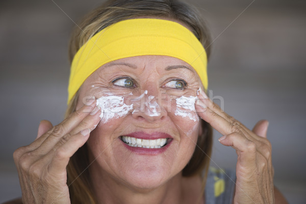 Skin care creme joyful mature woman Stock photo © roboriginal