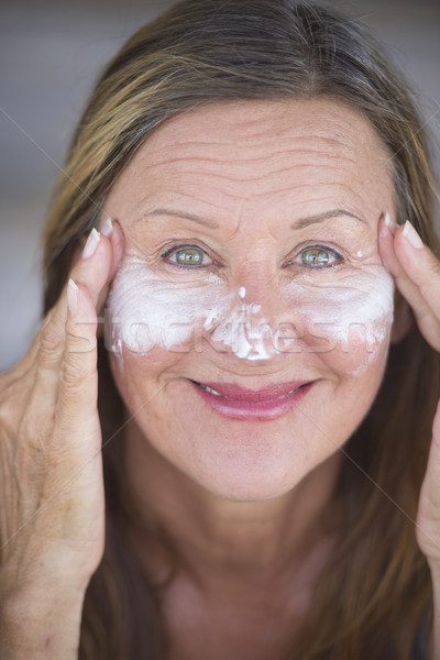 Happy mature woman face creme portrait Stock photo © roboriginal