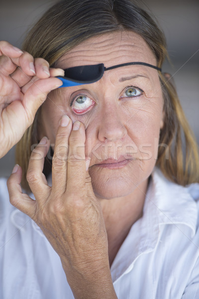 Injured matur woman lifting eye patch protection Stock photo © roboriginal