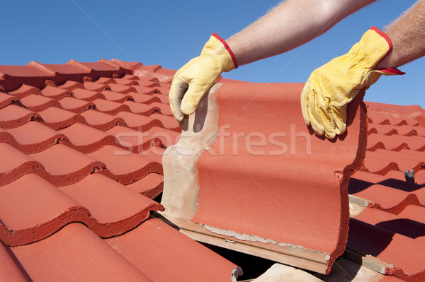 Stock photo: Construction worker tile house roofing repair 