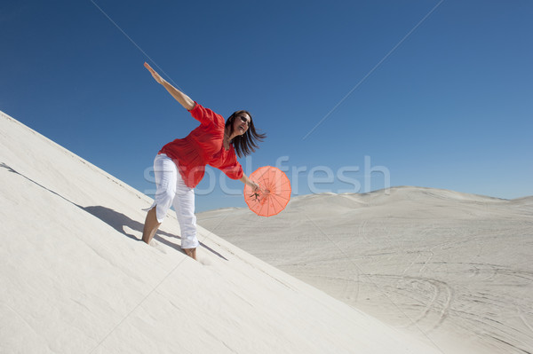 Attractive woman with umbrella on desert sand dune Stock photo © roboriginal