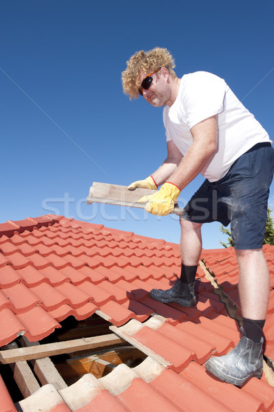 Trabajador de la construcción azulejo techo reparación trabajador amarillo Foto stock © roboriginal