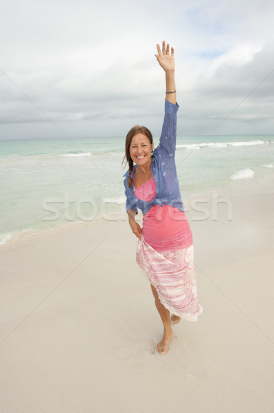 Mature woman enjoying herself on the beach Stock Photo - Alamy