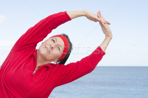 Stock photo: Middle aged woman stretching exercise ocean 