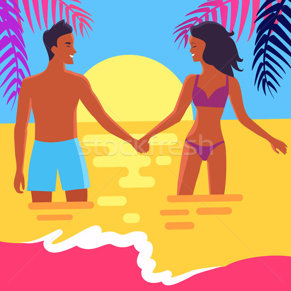 Poster of Happy Couple Standing in Sea at Sunset Stock photo © robuart
