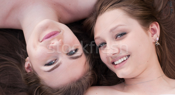 Two happy beautiful women lying heads together Stock photo © rosipro