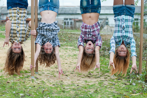 Patru tineri fete agatat cu susul in jos parc Imagine de stoc © rosipro