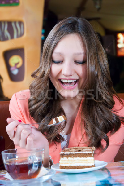 Stock photo: Happy young woman eating cake