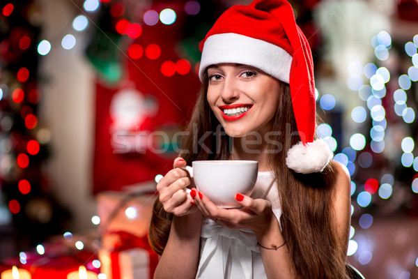 Fiatal nő kávéscsésze karácsony ül kalap díszített Stock fotó © RossHelen