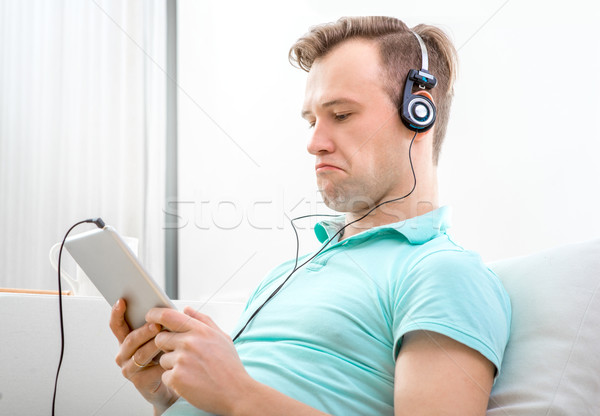 Férfi zenét hallgat jóképű férfi tabletta fejhallgató ül Stock fotó © RossHelen