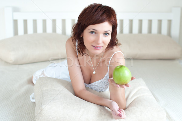 attractive young woman with an green apple at bed Stock photo © rozbyshaka