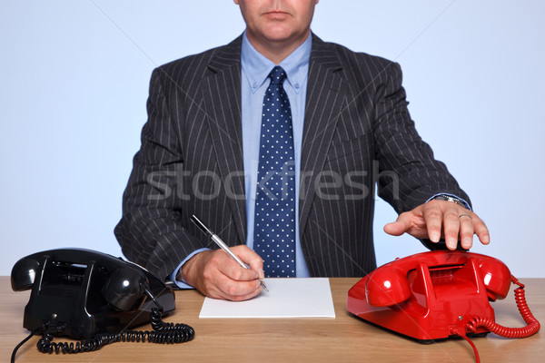 Businessman sat at desk with two telephones. Stock photo © RTimages