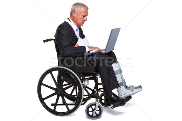 Injured businessman on laptop in a wheelchair isolated Stock photo © RTimages