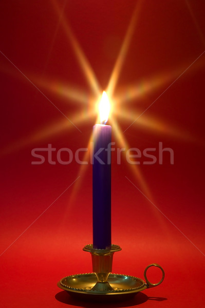 Blue candle in brass holder on red. Stock photo © RTimages