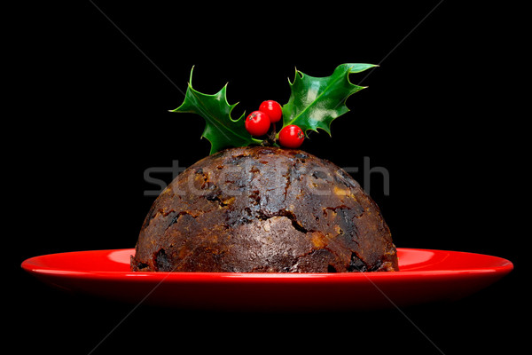 Christmas pudding with holly isolated on black Stock photo © RTimages