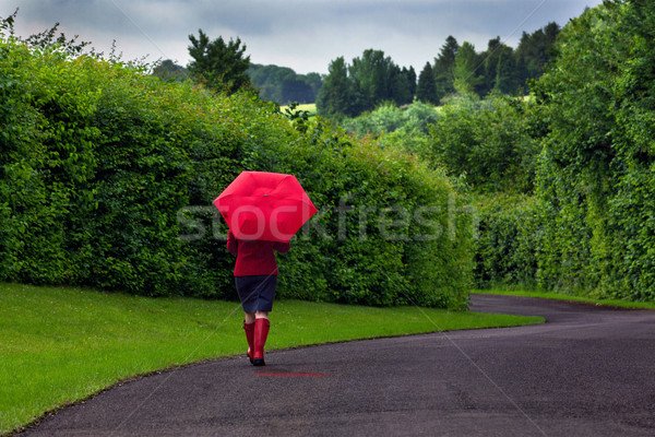 Woman with red umbrella on an overcast day. Stock photo © RTimages