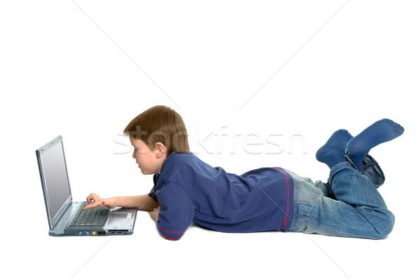 Boy laying down using a laptop  Stock photo © RTimages