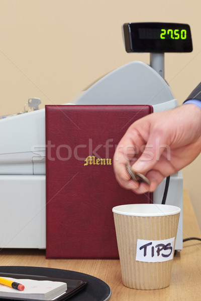 Stock photo: Man dropping coins in restaurant tip jar