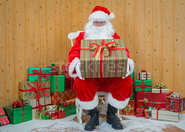 Santa Claus in his grotto holding a gift wrapped present Stock photo © RTimages