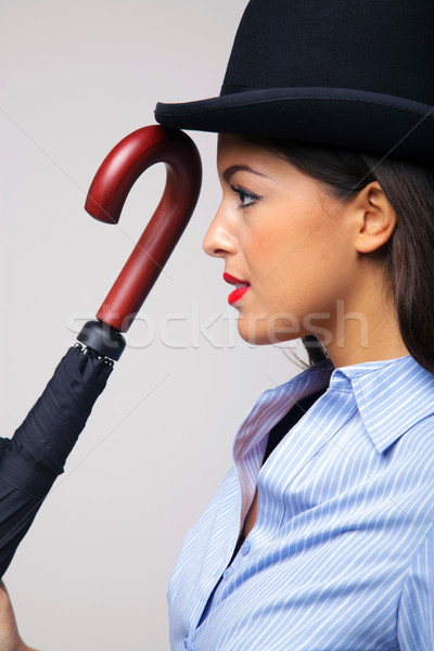 Businesswoman in bowler hat with umbrella. Stock photo © RTimages