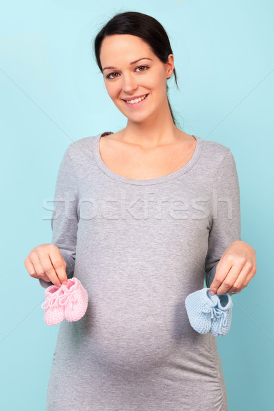 Pregnant woman holding baby booties Stock photo © RTimages