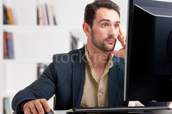 Suprised Man Looking At A Computer Monitor Stock photo © ruigsantos