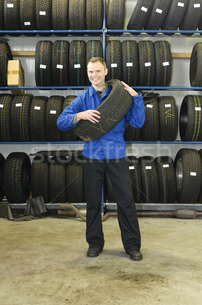 Man in the tire store with a tire, smiling Stock photo © runzelkorn