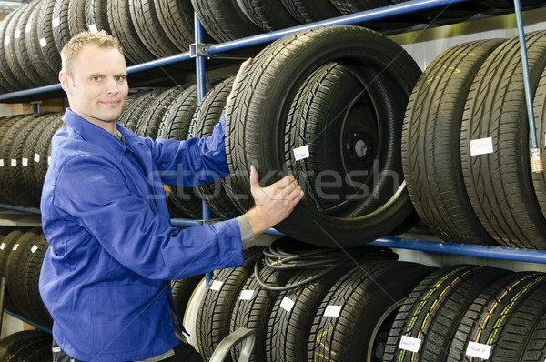 Homem pneu armazenar carro mecânico azul Foto stock © runzelkorn