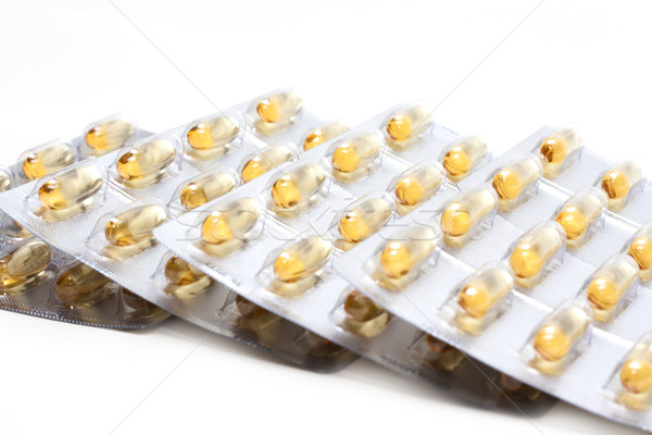 Stock photo: Packing the capsules cod-liver oil