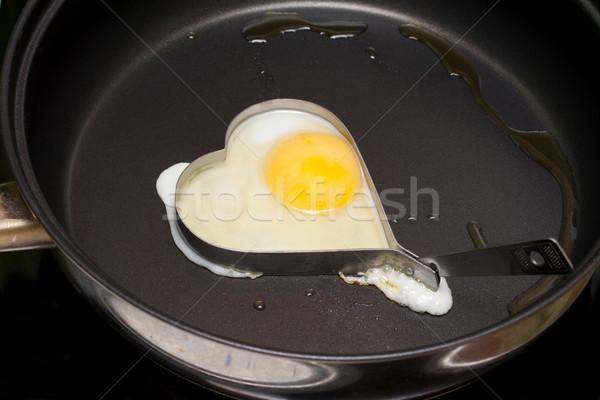 Fried egg in iron form heart Stock photo © RuslanOmega