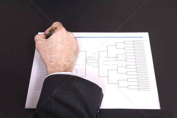 Stock photo: March Madness Businessman Hand Filling In Bracket From Above