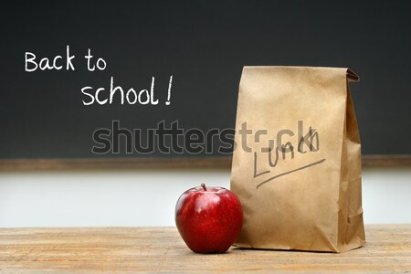 Stock photo: Lunch bags with apples and school bell on desk