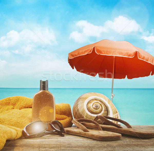 Bronzage lotion serviette sandales plage ciel Photo stock © Sandralise