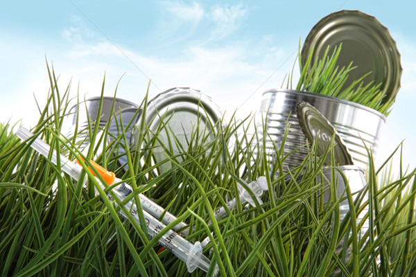 Syringe needles and food cans left in the grass  Stock photo © Sandralise