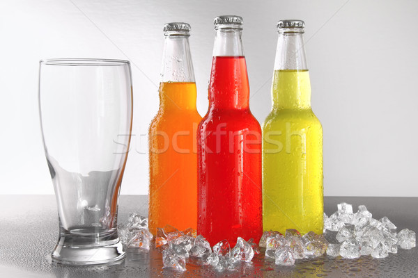 Three bottles with drinks with glass and ice Stock photo © Sandralise