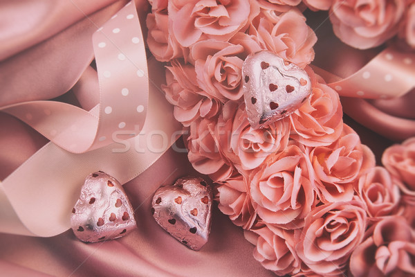 Heart made of pink roses with ribbons and chocolates on satin Stock photo © Sandralise