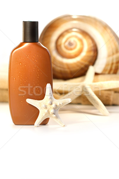 Stock photo: Sun lotion with seahells and towel 