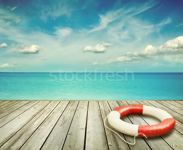 Wood pier with ocean and life preserver Stock photo © Sandralise