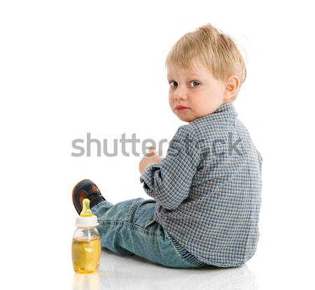 Assoiffé garçon séance bouteille isolé blanche Photo stock © sapegina